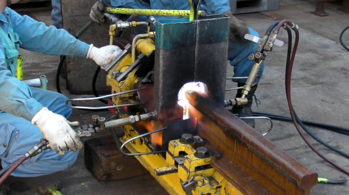 2人の作業員がレールを接合する様子